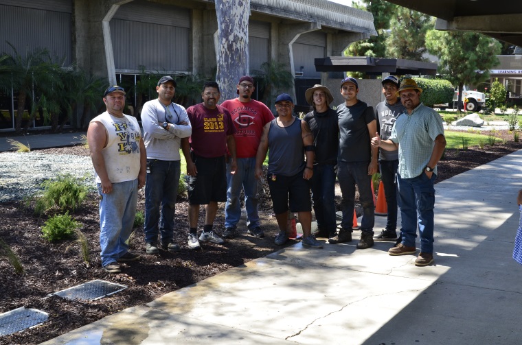 district gardeners and maintenance workers pose by plants