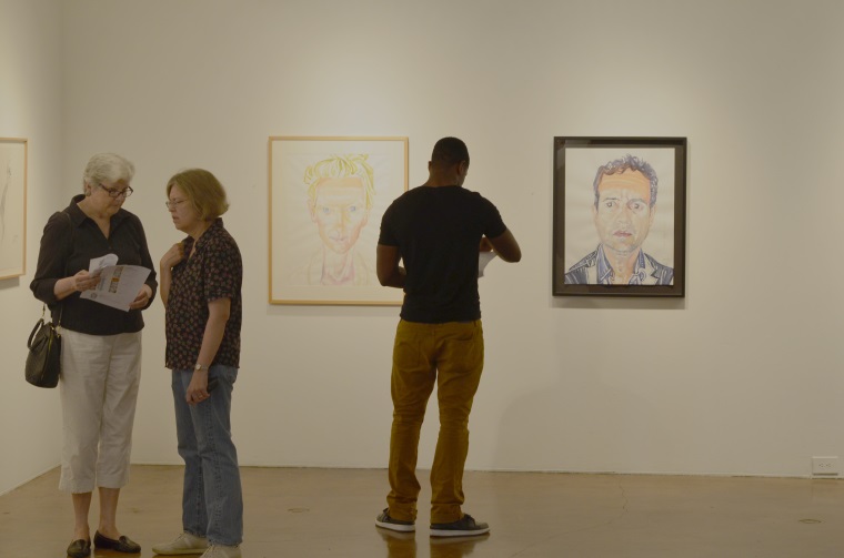 Southwestern College Art Gallery patrons glance at two portraits by artist Don Bachardy. On the left is a portrait of actress Tilda Swinton; on the right, a portrait of actor Mark Ruffalo
