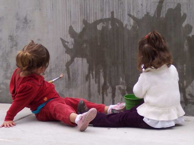 Photo of two children water painting