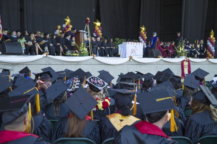 Graduates watch fellow students walk across the stage to receive their degrees. More than 625 students took the walk