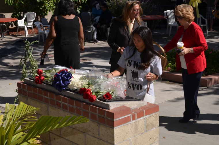 A student places a rose on the Veterans Memorial during the SWC Veterans Day Ceremony