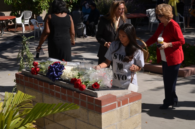 A student places a rose on the Veterans Memorial during the SWC Veterans Day Ceremony
