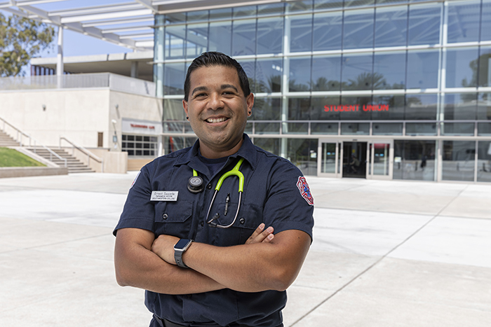 SWC Paramedic student, Ernest Sauceda smiling in front of the SWC Student Union in uniform.