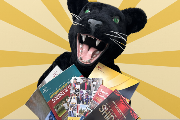 SWC mascot, Johnny Jaguar, holding collateral materials
